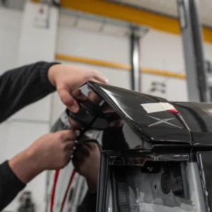 An Apache spoiler being attached to the back of a Defender 90