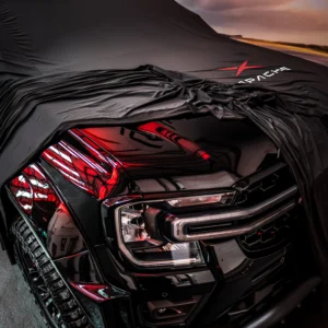A Black Apache Ford Ranger under a black Apache cover with just the front corner unwrapped